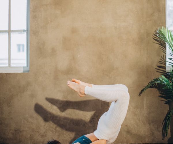 Woman performing a yoga pose that demonstrates core strength and stability.